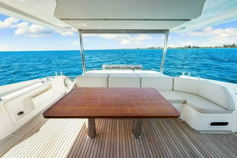 Mama's House Yacht Photos Pics Luxury Absolute 60 Flybridge yacht deck with wooden table, ocean view, 2018 model.