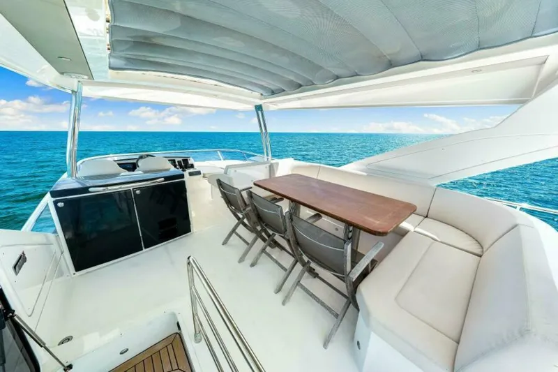 Mama's House Yacht Photos Pics Luxurious 2018 Absolute 60 Flybridge yacht with spacious outdoor seating and ocean view.