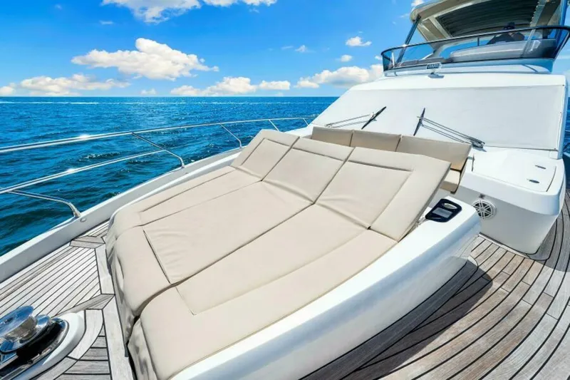 Mama's House Yacht Photos Pics Luxurious 2018 Absolute 60 Flybridge yacht with sunbathing area, cruising on open sea.