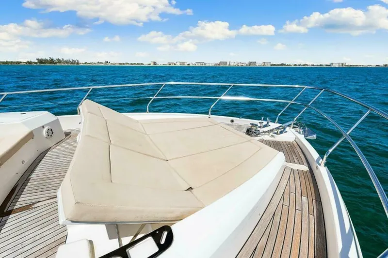 Mama's House Yacht Photos Pics 2018 Absolute 60 Flybridge yacht with sunbed, cruising on blue ocean under clear sky.