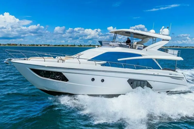 Mama's House Yacht Photos Pics Luxurious 2018 Absolute 60 Flybridge yacht cruising on open water under clear blue skies.