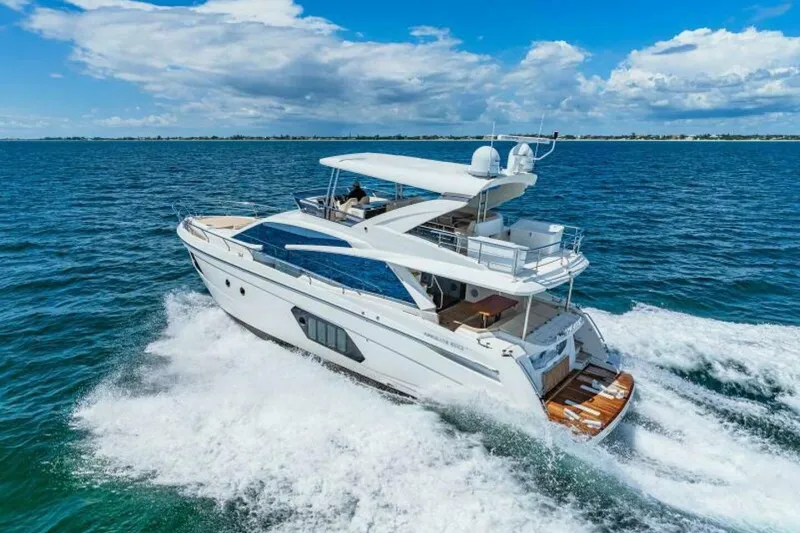 Mama's House Yacht Photos Pics Luxury 2018 Absolute 60 Flybridge yacht cruising on open sea under blue sky.