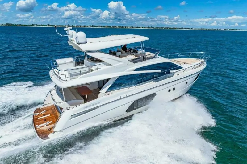 Mama's House Yacht Photos Pics Luxury 2018 Absolute 60 Flybridge yacht cruising on open sea under blue sky.