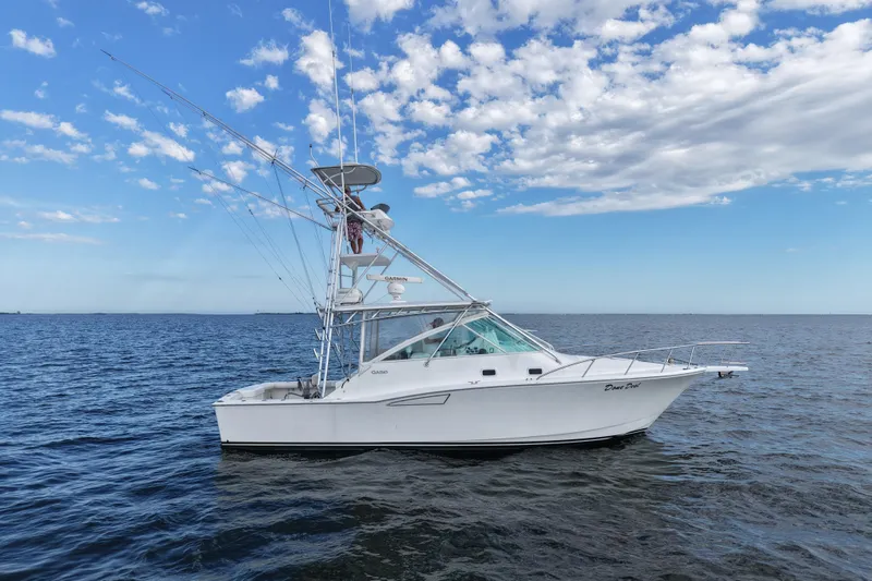 Done Deal Yacht Photos Pics 2001 Cabo 35 Express boat on open water under a partly cloudy sky.