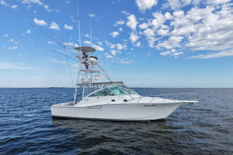 Done Deal Yacht Photos Pics 2001 Cabo 35 Express boat on open water under a partly cloudy sky.