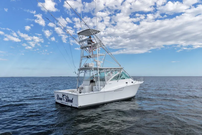 Done Deal Yacht Photos Pics 2001 Cabo 35 Express boat on open water under a partly cloudy sky.