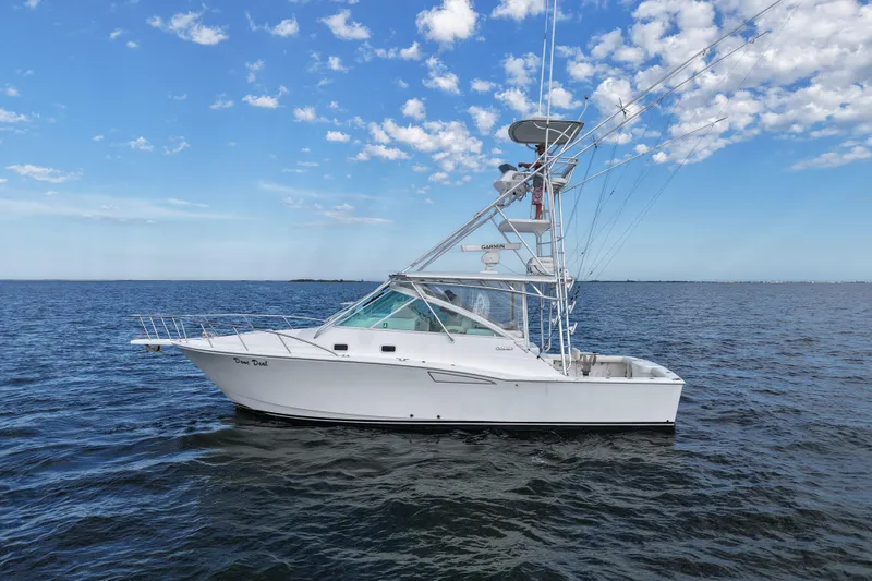 Done Deal Yacht Photos Pics 2001 Cabo 35 Express boat on open water under a clear blue sky.
