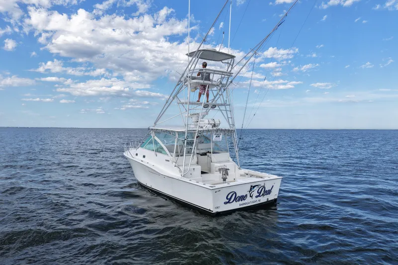 Done Deal Yacht Photos Pics 2001 Cabo 35 Express boat on open water under a blue sky.