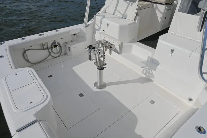 Done Deal Yacht Photos Pics 2001 Cabo 35 Express boat deck with fishing rod holder, white seating, and storage compartments.