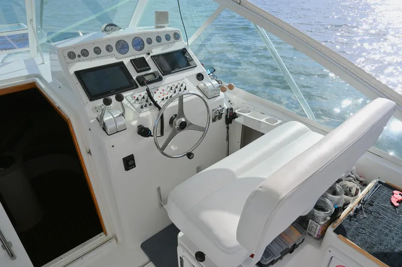 Done Deal Yacht Photos Pics Cockpit of 2001 Cabo 35 Express boat with steering wheel and navigation controls.
