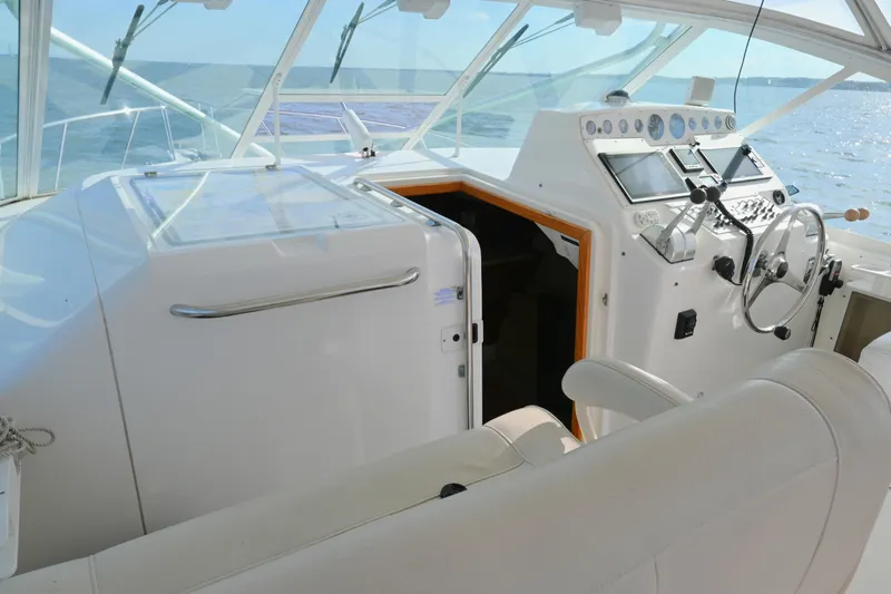Done Deal Yacht Photos Pics 2001 Cabo 35 Express boat cockpit with steering wheel and navigation controls.