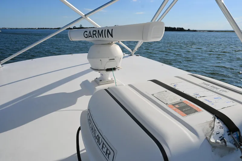 Done Deal Yacht Photos Pics 2001 Cabo 35 Express boat with Garmin radar on deck, cruising on open water.