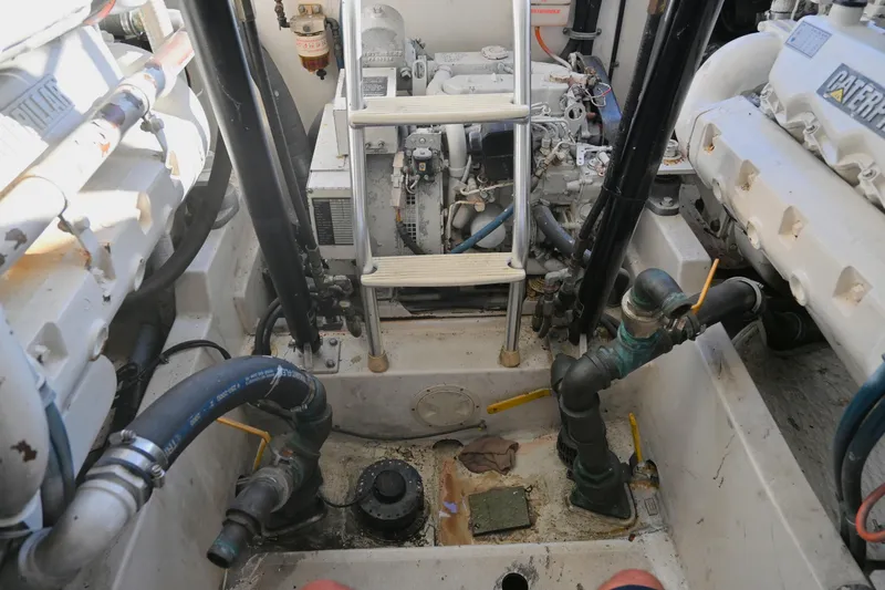 Done Deal Yacht Photos Pics Engine room of a 2001 Cabo 35 Express boat, featuring mechanical components and piping.