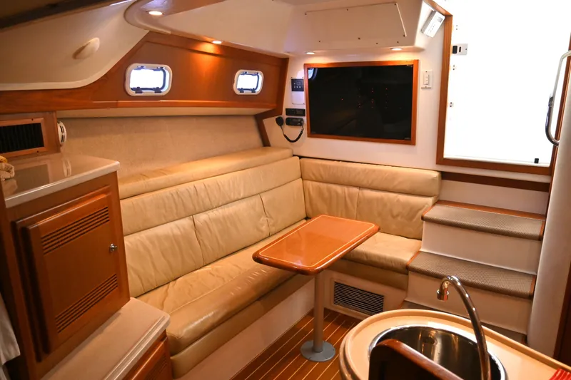 Done Deal Yacht Photos Pics Interior of 2001 Cabo 35 Express yacht with cozy seating and wooden accents.
