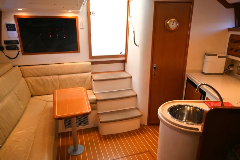 Done Deal Yacht Photos Pics Interior of 2001 Cabo 35 Express yacht with seating, table, and kitchenette.