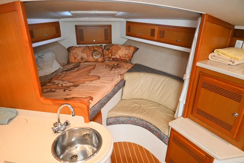 Done Deal Yacht Photos Pics Cozy cabin interior of 2001 Cabo 35 Express with bed, seating, and sink.