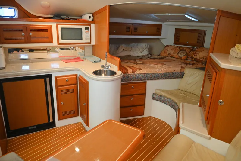 Done Deal Yacht Photos Pics Interior of 2001 Cabo 35 Express boat with kitchenette and cozy sleeping area.