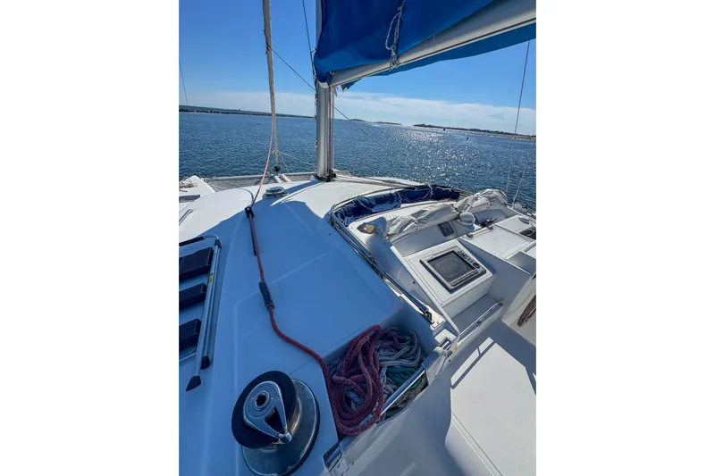 Liberty Yacht Photos Pics Catamaran deck view, Lagoon 440, 2005 model, sailing on calm waters under clear blue sky.