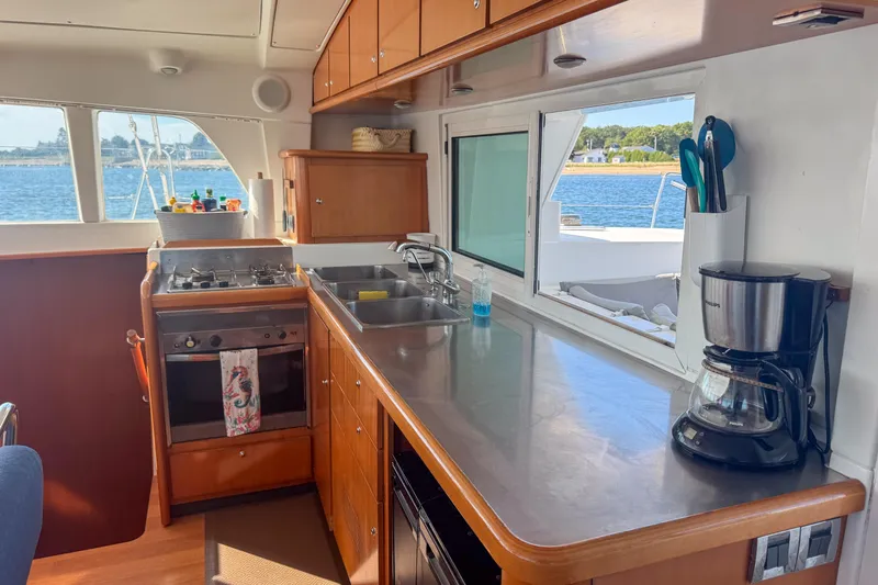 Liberty Yacht Photos Pics Interior of 2005 Lagoon 440 catamaran kitchen with stove, sink, and coffee maker.
