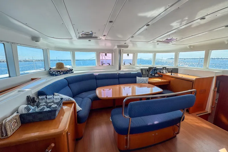 Liberty Yacht Photos Pics Interior of 2005 Lagoon 440 catamaran with panoramic windows and cozy seating area.