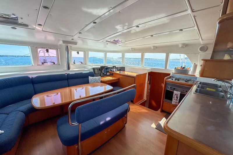 Liberty Yacht Photos Pics Interior of 2005 Lagoon 440 catamaran with spacious seating, kitchen, and ocean view.