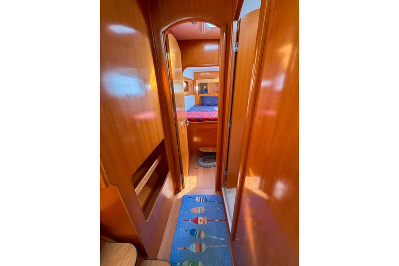 Liberty Yacht Photos Pics Interior view of 2005 Lagoon 440 yacht cabin with wooden finish and colorful rug.