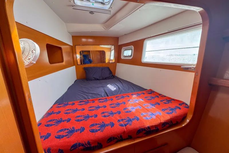Liberty Yacht Photos Pics Cozy cabin interior of 2005 Lagoon 440 catamaran with bed and window.