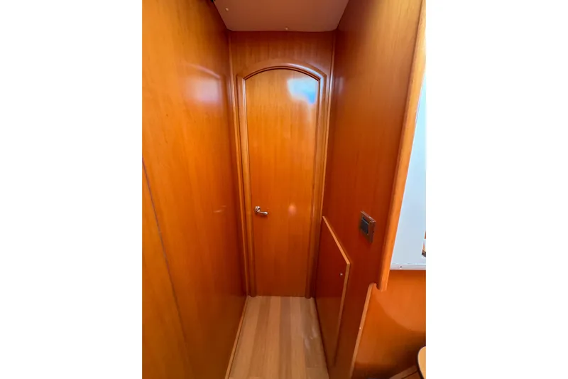 Liberty Yacht Photos Pics Interior hallway of 2005 Lagoon 440 yacht with wooden paneling and door.