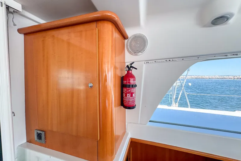 Liberty Yacht Photos Pics Interior of 2005 Lagoon 440 yacht with wooden cabinet and fire extinguisher.