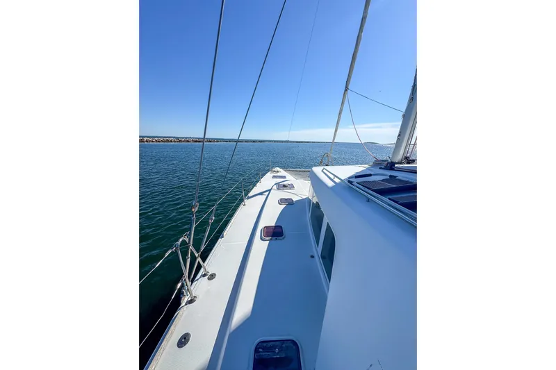 Liberty Yacht Photos Pics 2005 Lagoon 440 catamaran sailing on calm waters under clear blue skies.