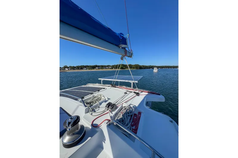 Liberty Yacht Photos Pics 2005 Lagoon 440 catamaran on calm water with clear blue sky.