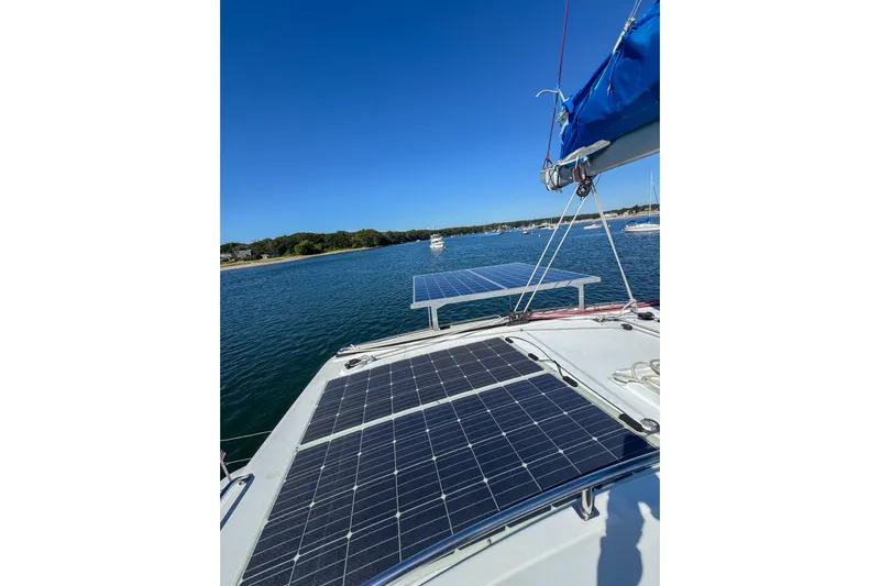 Liberty Yacht Photos Pics Catamaran Lagoon 440 (2005) with solar panels on deck, sailing in sunny waters.
