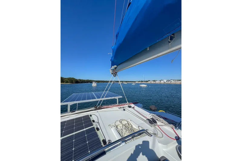 Liberty Yacht Photos Pics 2005 Lagoon 440 catamaran with solar panels, anchored in a scenic bay.