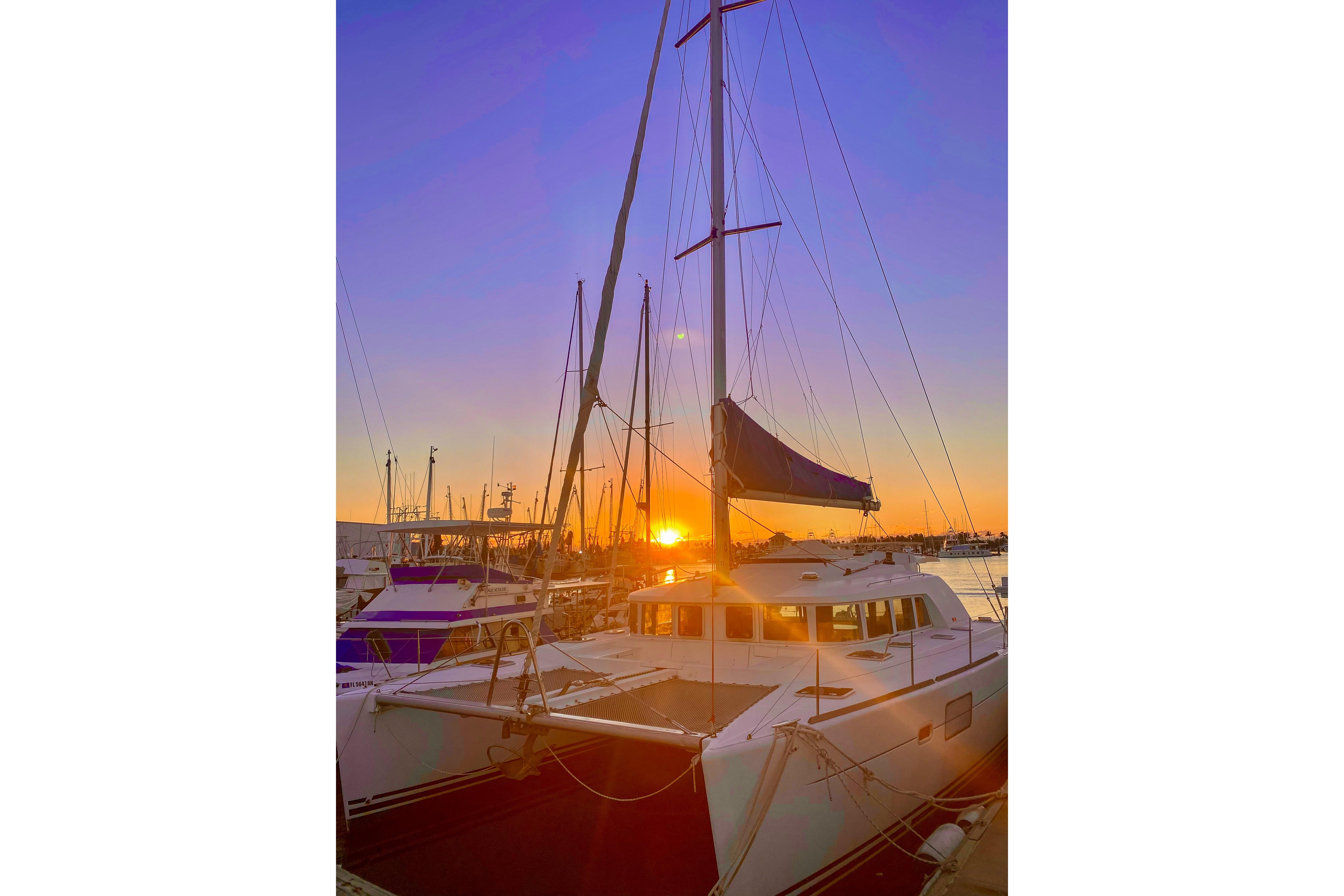 Sunset view of a 2005 Lagoon 440 catamaran docked at a marina.