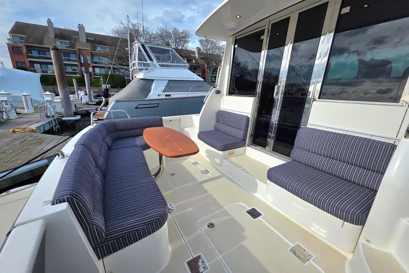  Yacht Photos Pics 2017 Sabre 42 Salon Express yacht with outdoor seating and table at a marina.