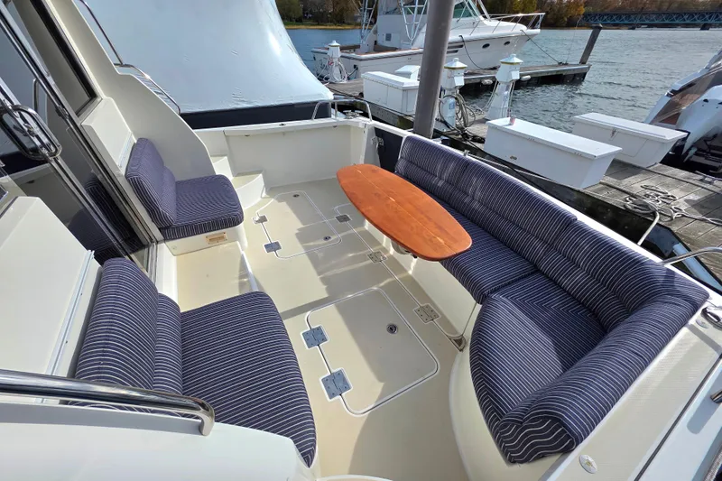  Yacht Photos Pics 2017 Sabre 42 Salon Express yacht with striped seating and wooden table on deck.