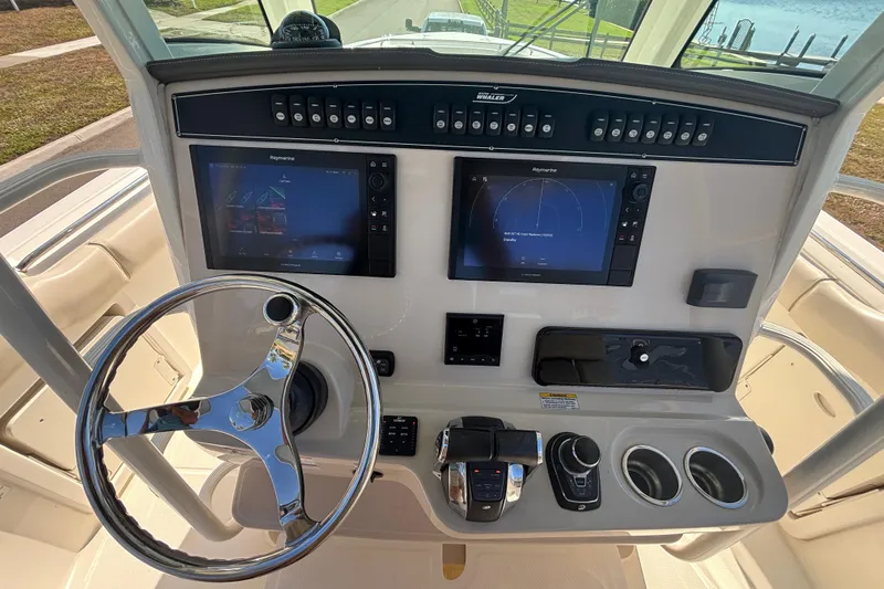  Yacht Photos Pics 2021 Boston Whaler 330 Outrage helm with dual Raymarine displays and chrome steering wheel.
