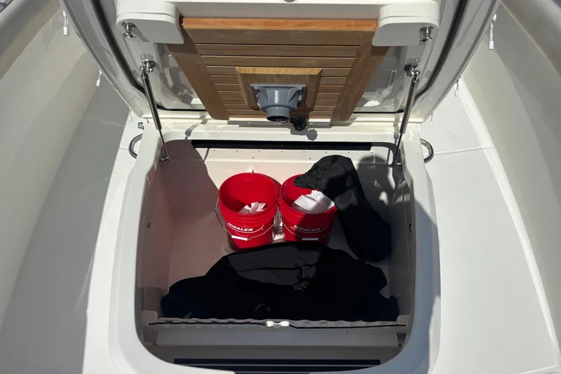  Yacht Photos Pics Storage compartment on a 2021 Boston Whaler 330 Outrage with red buckets and black covers.