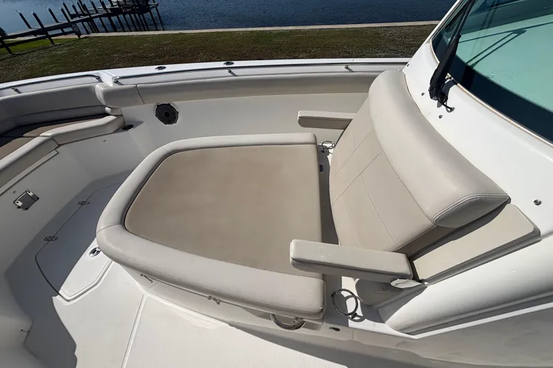  Yacht Photos Pics Boston Whaler 330 Outrage 2021 boat seating area with beige cushions by the water.