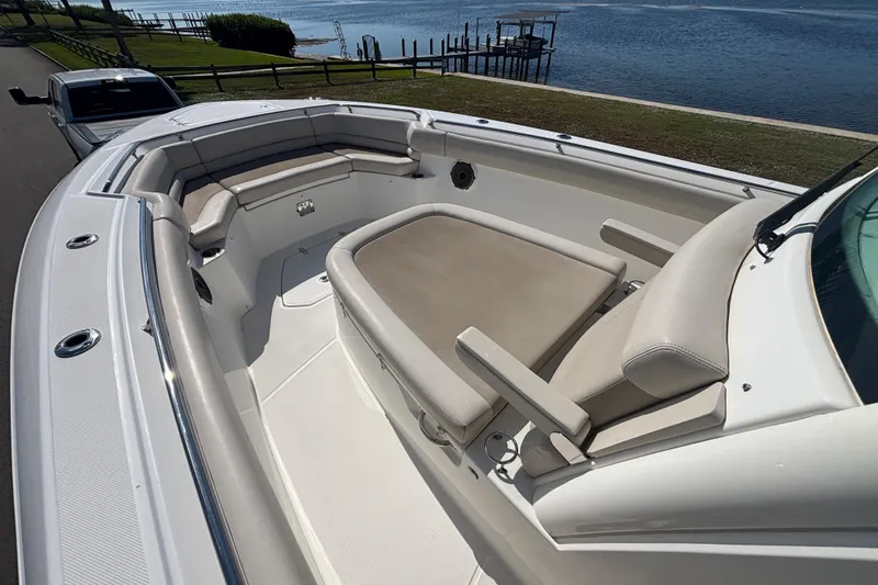  Yacht Photos Pics 2021 Boston Whaler 330 Outrage boat with spacious seating, docked by a scenic waterfront.