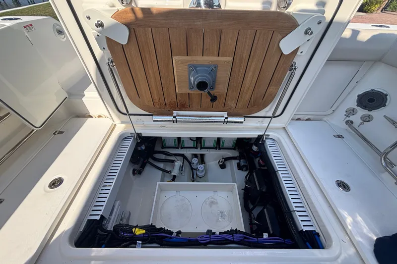  Yacht Photos Pics 2021 Boston Whaler 330 Outrage boat storage compartment with open hatch and visible wiring.