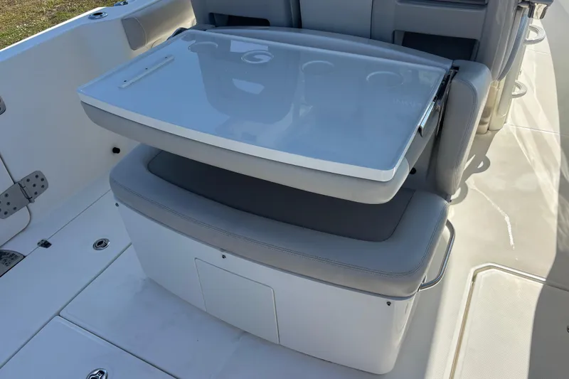  Yacht Photos Pics 2021 Boston Whaler 330 Outrage boat seating with foldable table and storage compartment.