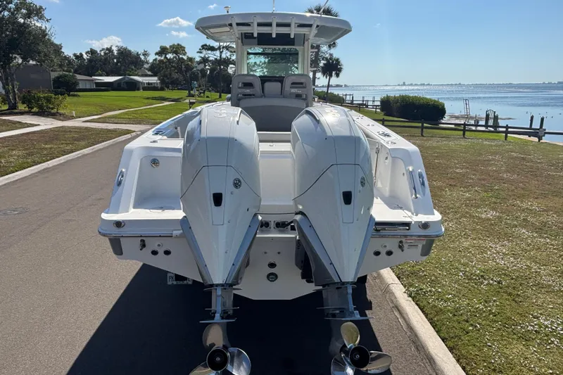  Yacht Photos Pics 2021 Boston Whaler 330 Outrage boat with dual engines, parked near a waterfront.