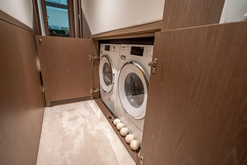 Triangle Of The Seas Yacht Photos Pics Laundry area with washer and dryer on Azimut Magellano 66 yacht, 2022 model.