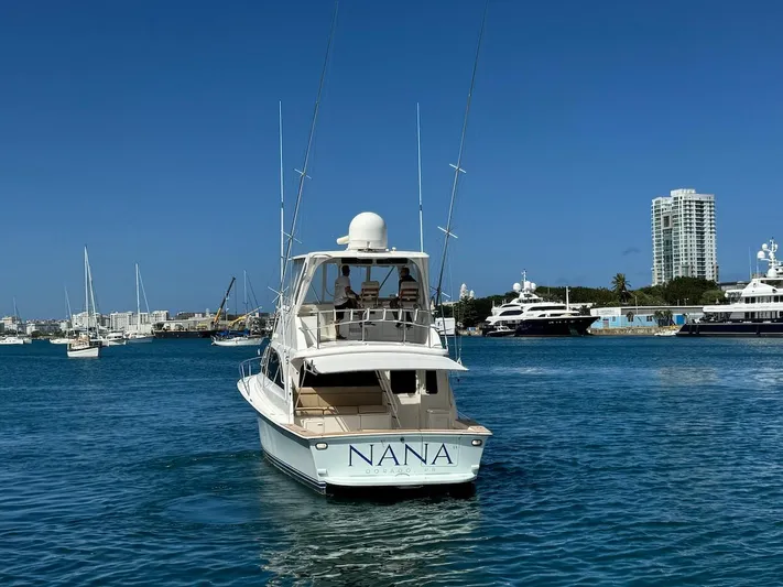 Nana Yacht Photos Pics Ocean Yachts 48 Convertible 2000 in marina, clear blue sky, cityscape background.