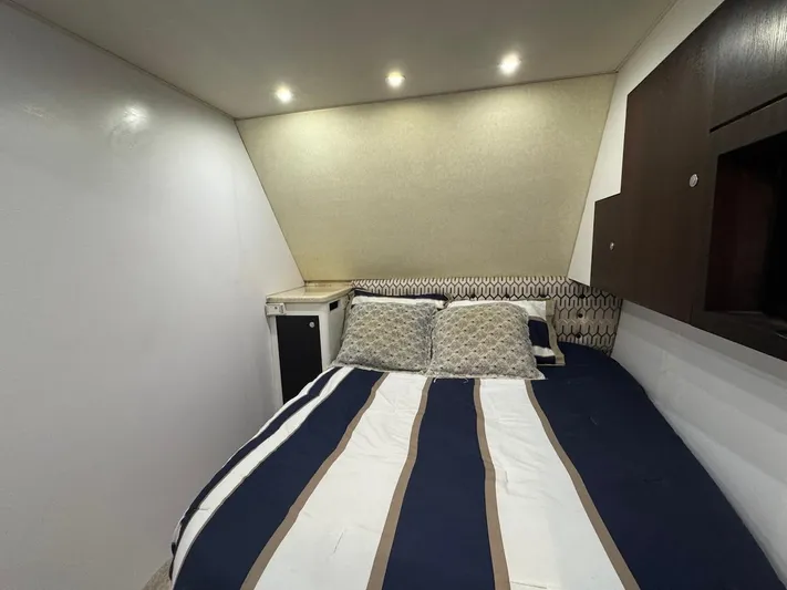 Nana Yacht Photos Pics Cozy bedroom in 2000 Ocean Yachts 48 Convertible with striped bedding and modern lighting.