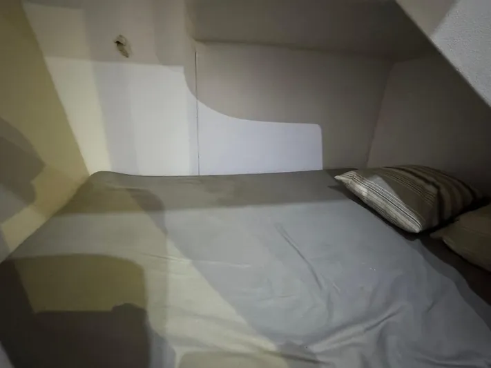 Nana Yacht Photos Pics Small cabin bed in 2000 Ocean Yachts 48 Convertible, featuring simple bedding and pillows.