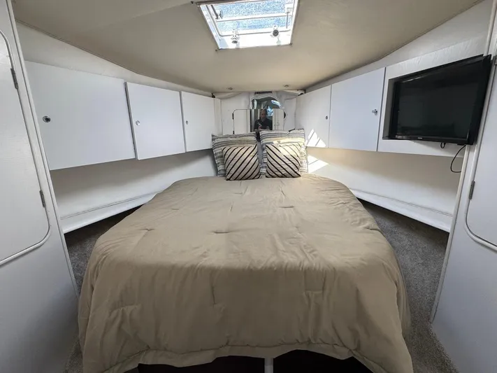 Nana Yacht Photos Pics Interior cabin of 2000 Ocean Yachts 48 Convertible with bed, storage, and TV.