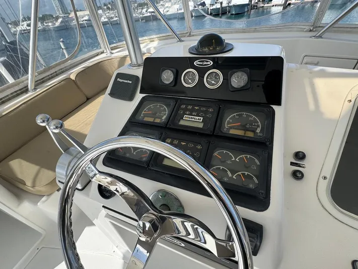 Nana Yacht Photos Pics Helm of 2000 Ocean Yachts 48 Convertible with gauges and steering wheel, docked at marina.