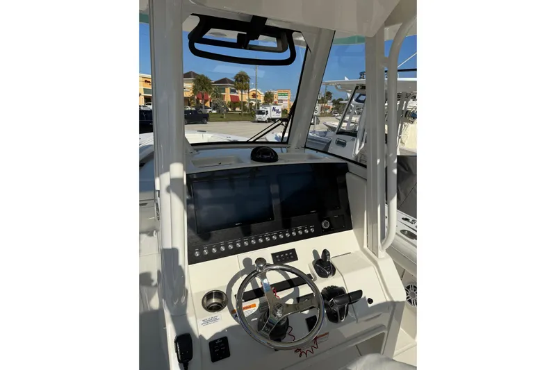 28-563 Brokerage Higgins Yacht Photos Pics 2021 Regulator 28 boat cockpit with modern steering and navigation controls.